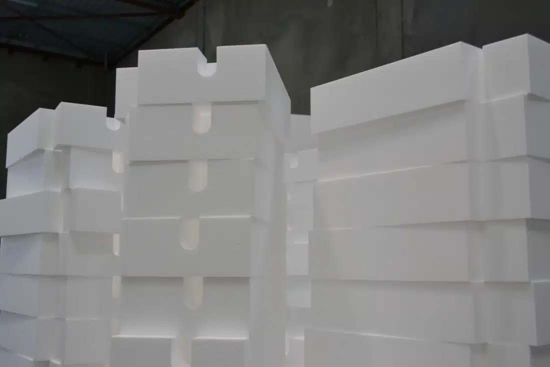 An image of polystyrene packing used in Perth, specifically custom EPS packaging. The image shows a variety of custom-cut foam packaging pieces, made of expanded polystyrene (EPS) foam, used to protect fragile items during transportation. The foam pieces are designed to fit specific shapes and sizes, providing a secure and snug fit for the items while also cushioning them against any impacts or shocks that may occur during shipping.