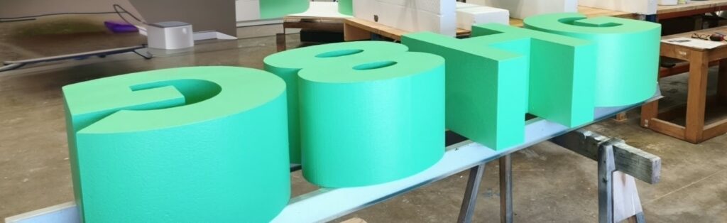 Green dimensional foam lettering on a workbench